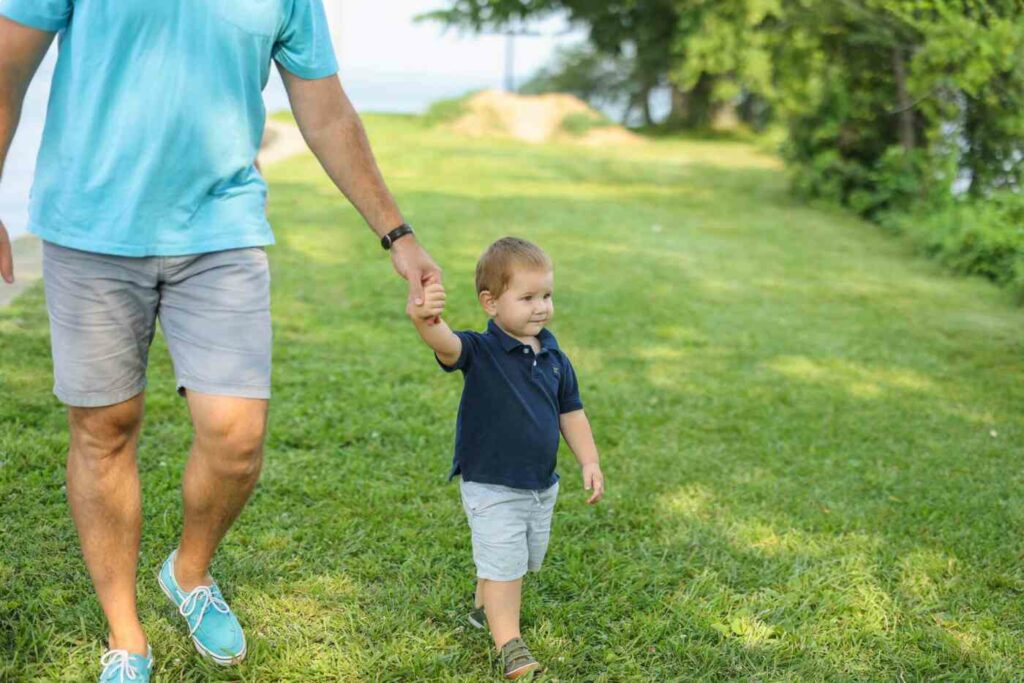 dad and child holding hands walking
